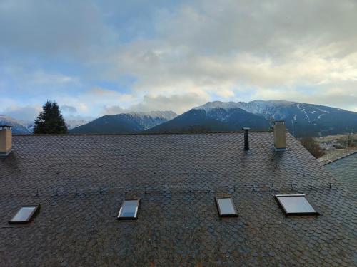 a roof with skylights on it with mountains in the background at Joli appartement à Mont-Louis in Mont-Louis