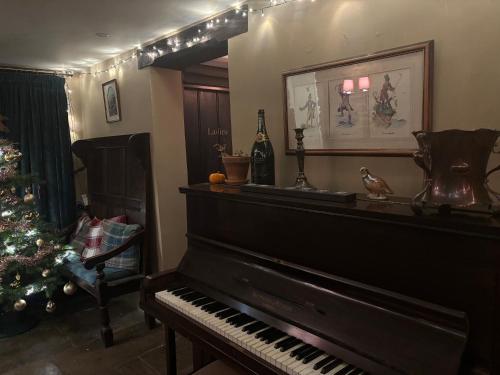 a living room with a piano and a christmas tree at The Royal Oak in Eydon
