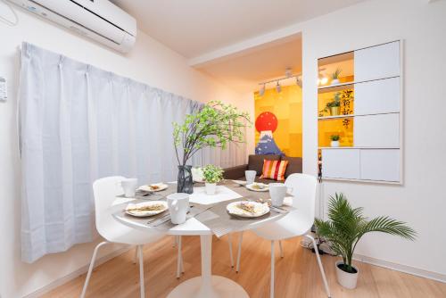 a white dining room with a white table and chairs at LEON RESORT HOTEL A 3rooms MAX8people 6min Shinjuku 11min Shibuya 12min walk Ikebukuro LEON RESORT IKEBUKURO traditional Japanese room 池袋 最大8名 in Tokyo