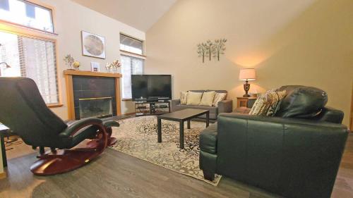 a living room with a couch and chairs and a fireplace at Skyline Condo 02 in Sunriver