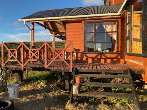 a cabin with a wooden deck and a window at Cabaña 2 pisos in Natri