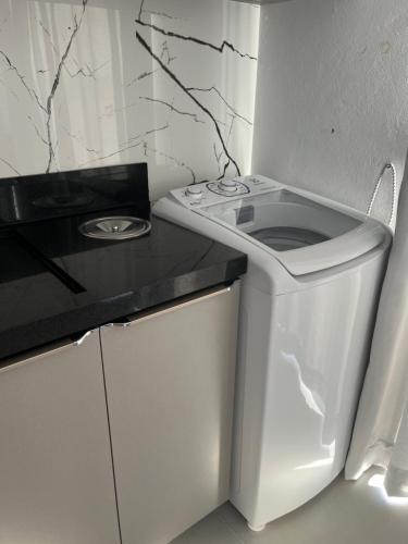 a small kitchen with a white stove and a counter at Eu Sou do Mar apto térreo 1 in Palhoça