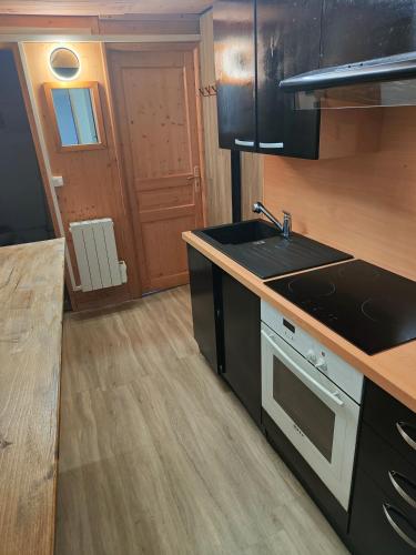 une cuisine avec un évier et une cuisinière four supérieur dans l'établissement Joli appartement à Mont-Louis, à Mont-Louis