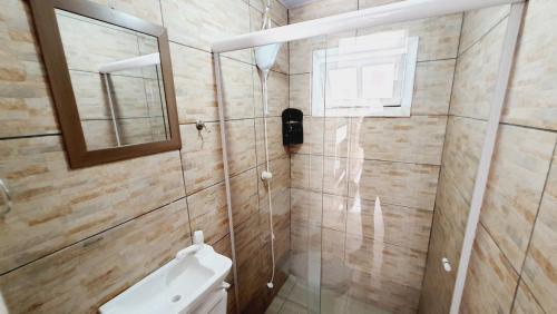 um banheiro com vaso sanitário e box de vidro em Open House Canasvieiras - OH HOTÉIS em Florianópolis