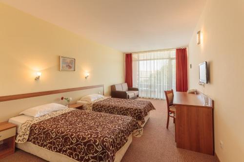 a hotel room with two beds and a desk at Hotel RIAGOR - ALL INCLUSIVE in Sunny Beach