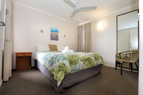 a bedroom with a bed and a mirror at Horizons 3 in Bargara