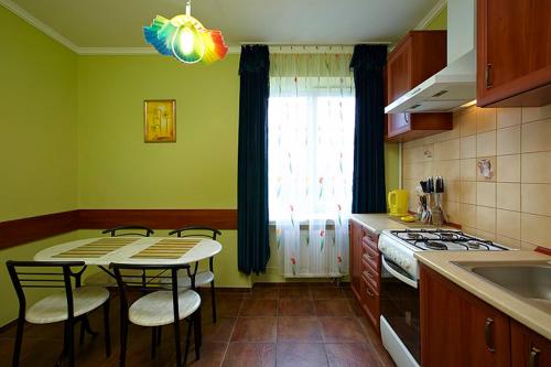 y cocina con mesa, sillas y fogones. en Apartment Oksi en Leópolis