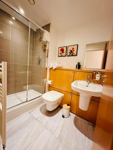 a bathroom with a toilet and a sink and a shower at Scotapartments in Edinburgh