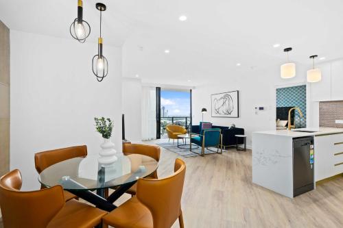 a kitchen and dining room with a glass table and chairs at Stay Luxe Southport - Hosted by Coastal Letting Co. in Gold Coast