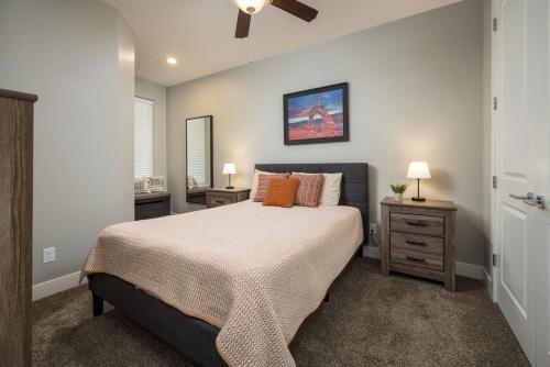 Un dormitorio con una cama grande y dos mesitas de noche. en Downtown Moab Basecamp Pool & Hot Tub - Entrada, en Moab