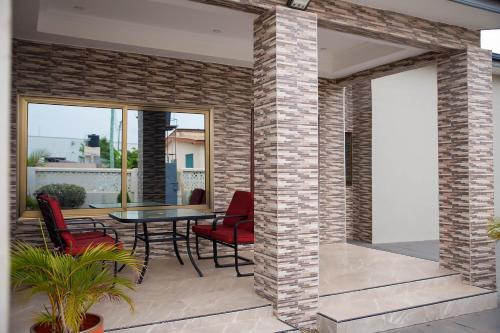 a patio with red chairs and a table at Gated Community in Kwedonu