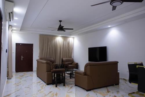 a waiting room with chairs and a flat screen tv at Gated Community in Kwedonu