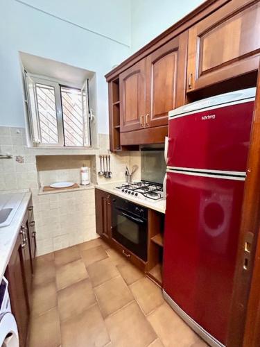 a kitchen with a red refrigerator and wooden cabinets at Mussomeli Palazzo in Mussomeli