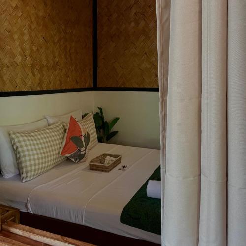 a bedroom with a bed with a curtain at Hidden of Cailan Extension Transient House in El Nido
