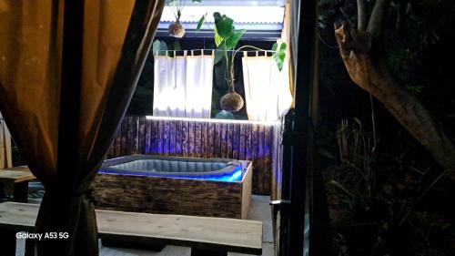 a room with a tub and a window with curtains at La Case Floria in Saint-André
