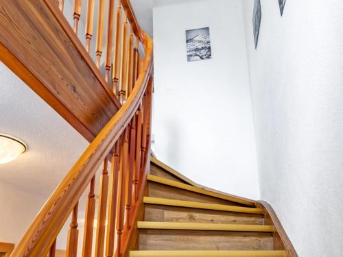 a wooden staircase in a building with a clock on the wall at Haus Filzstein in Unterkrimml