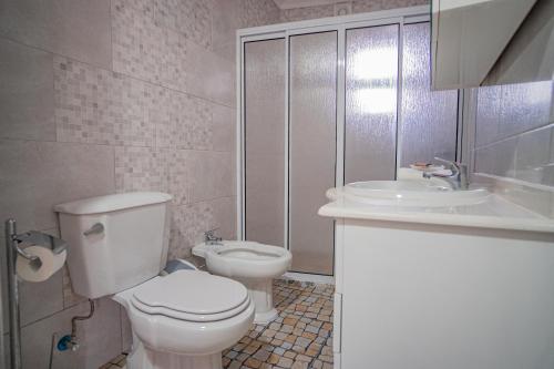 ein weißes Badezimmer mit Toilette und Waschbecken in der Unterkunft Vivenda Graciosa in Boa Hora