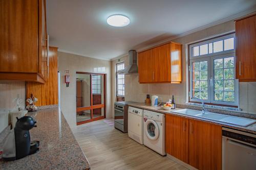 a kitchen with a sink and a washer and dryer at Vivenda Graciosa in Boa Hora