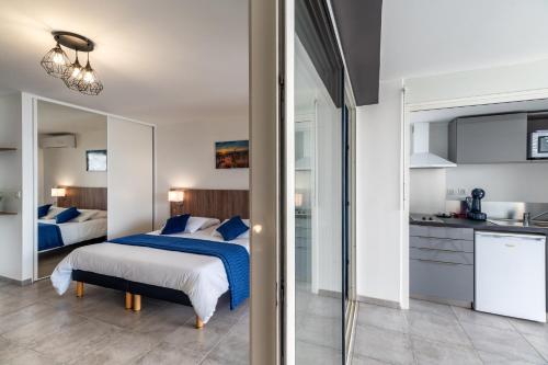a bedroom with two beds and a kitchen at B&B HOME Fort-de-France Marina in Fort-de-France