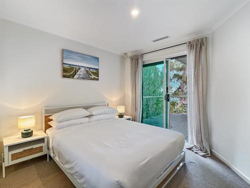 a bedroom with a bed and a large window at Spacious 4-Bed Home with Coastal Charm in Long Beach