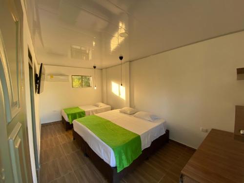 a small room with two beds in it at Hotel Sol del Desierto in Villavieja