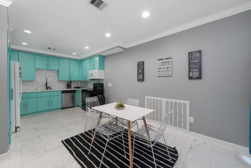 a kitchen with blue cabinets and a table and chairs at Spacious 2BR Apt with King Beds & Fully Equipped Kitchen in Houston