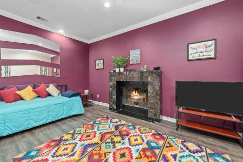 a living room with purple walls and a fireplace at Spacious 2BR Apt with King Beds & Fully Equipped Kitchen in Houston