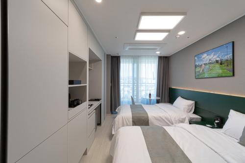 a bedroom with two beds and a large window at Bella Stay in Chuncheon