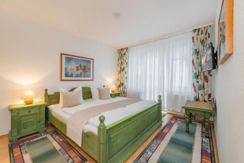 ein Schlafzimmer mit einem grünen Bett und einem Fenster in der Unterkunft Dünenresidenz 13 in Zinnowitz