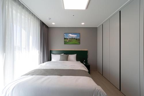 a bedroom with a large bed and a window at Bella Stay in Chuncheon
