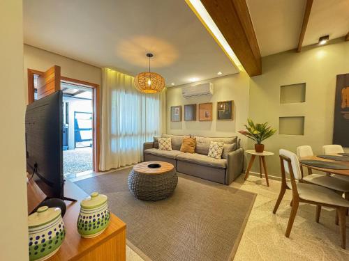 ein Wohnzimmer mit Sofa und Tisch in der Unterkunft Casa Bela - Centro - Ar condicionado Garagem Wi-fi in Águas de Lindóia