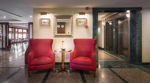 dos sillas rojas y una mesa en un pasillo en Titanic Comfort Sisli, en Estambul