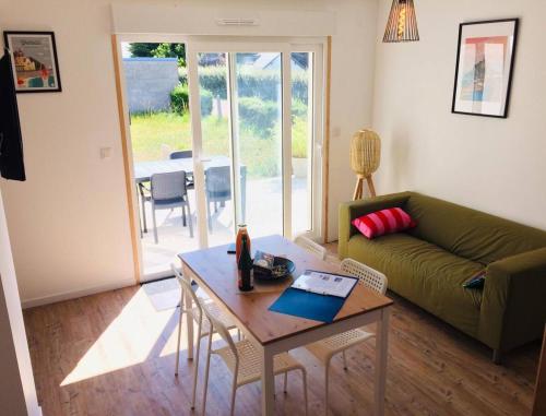 a living room with a couch and a table at Jacuzzi & Sauna privatifs - Vue mer in Blainville-sur-Mer