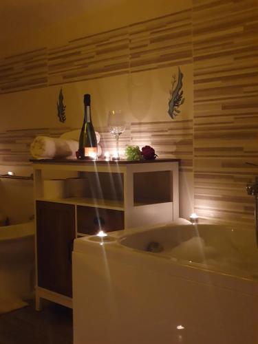 a bath tub with a bottle of wine and a glass at La Dolce Sosta - Tuscany in Chianciano Terme
