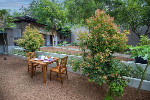 a wooden table and chairs in a garden at Villa Freedom in Hikkaduwa
