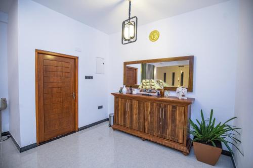 a bathroom with a wooden vanity and a mirror at Villa Freedom in Hikkaduwa