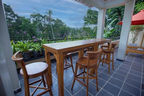 a porch with a wooden table and chairs on a balcony at Villa Freedom in Hikkaduwa
