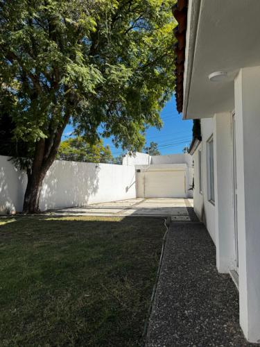 a building with a tree next to a white wall at Rubeta in Yelateni