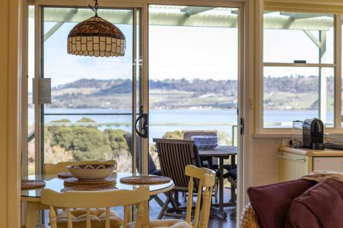 a kitchen and dining room with a view of the ocean at Olive's Cottage and Gardens - Mesmerising Views in Windermere