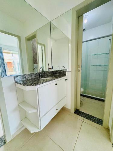 a bathroom with a sink and a large mirror at Casa brisa do mar 2 in Arraial do Cabo