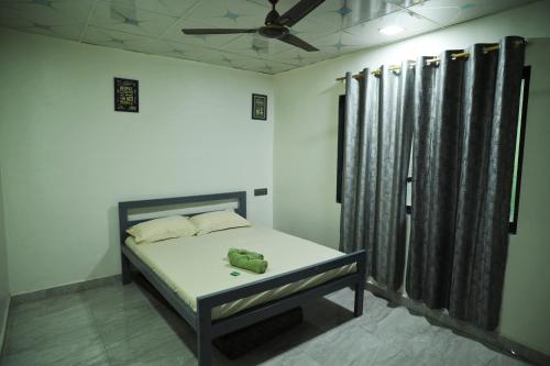 a bedroom with a bed and a ceiling fan at Anand hillside Retreat 3BR Pool Villa by Homeyhuts in Māndvi