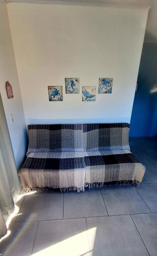 a bed in a room with pictures on the wall at Kitnet em Imbituba - Fabi in Imbituba