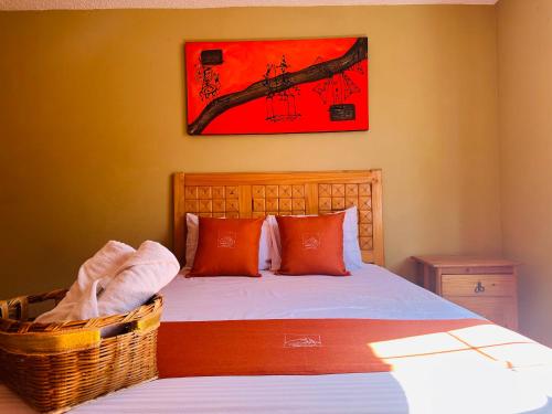 a bedroom with a bed and a painting on the wall at Hotel & Suites Cerro Roj0 in Tlatlauquitepec