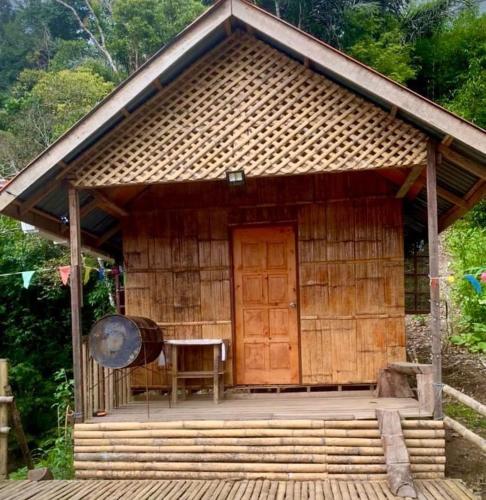 a small hut with a table and a wooden door at Baruk Mas Kampung Assum in Kuching