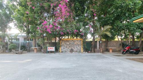 a parking lot with a gate with pink flowers at RedDoorz @ Farm Side Hotel Laoag City in Laoag