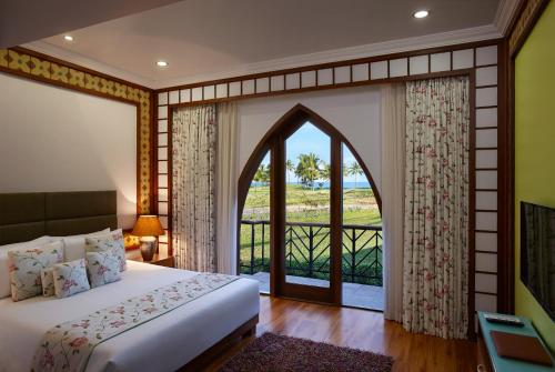 a bedroom with a bed and a large window at Caravela Beach Resort in Varca