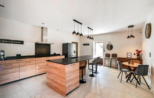 une cuisine avec un comptoir, une table et des chaises dans l'établissement Stunning Home In Orsan, à Orsan