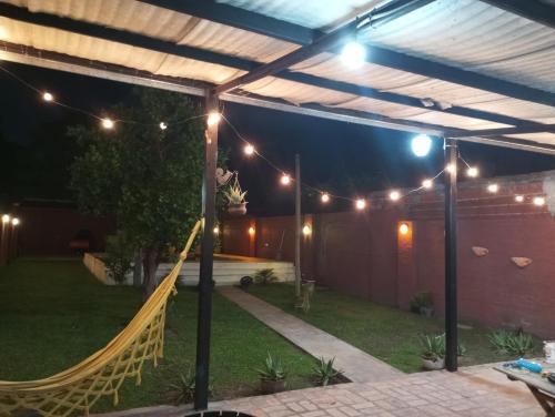 a patio with a hammock under a pergola at night at Casa con pileta frente a la Laguna Soto in Laguna Brava
