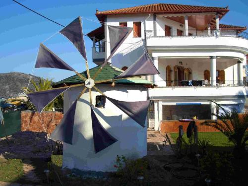 a house with a large clock in front of it at Aspri Villa in Ammoudia