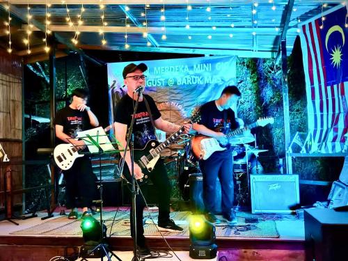 a group of people on a stage playing music at Baruk Mas Kampung Assum in Kuching